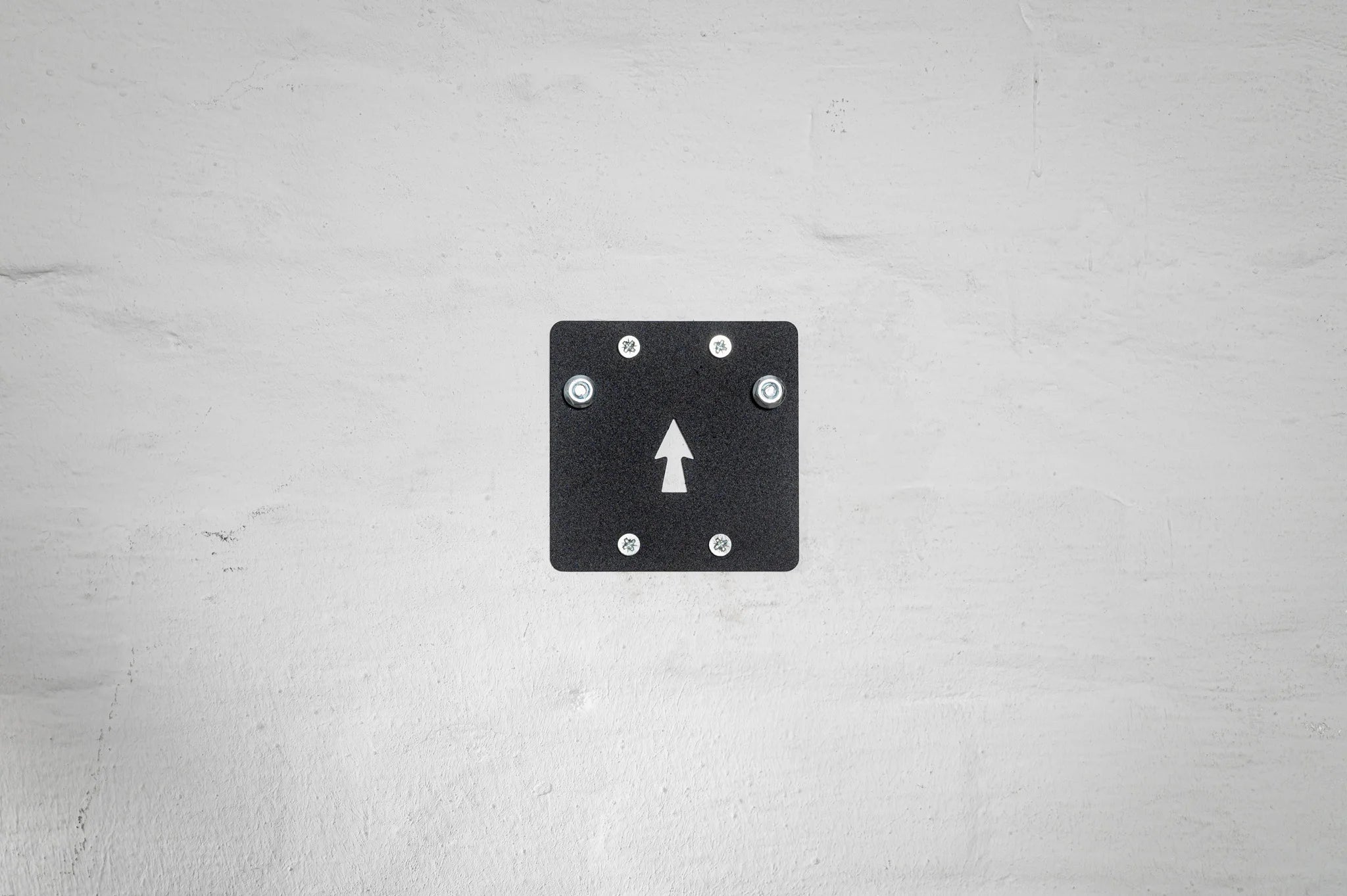 The black mounting plate of the Hold My Bike (HMB) wheel mount features a directional arrow for easy installation, ensuring perfect alignment on your wall.