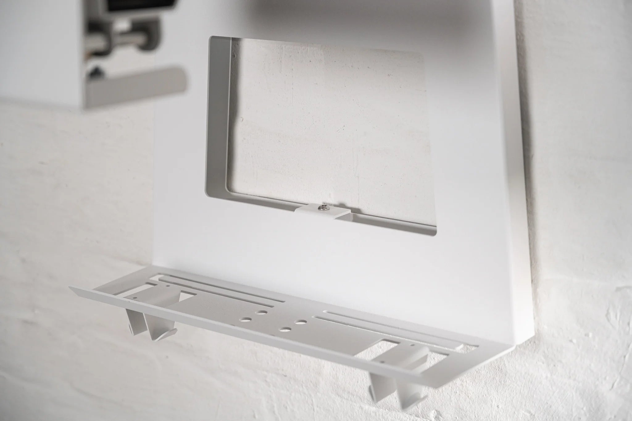 Close-up of the lower shelf and hanger rack on the white HMB Ultimate wall organizer, highlighting the precision-cut metal slots for jersey hangers and secondary storage space.