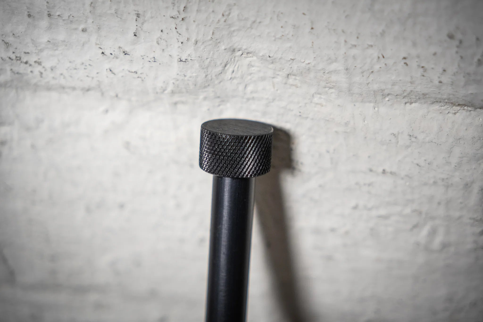 Close-up of the high-quality, black anodized thru-axle for the Hold My Bike (HMB) wheel mount, ensuring secure indoor bike wheel storage in apartments.