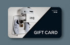 Hold My Bike (HMB) gift card for cyclists: White indoor bike wall mount featuring a helmet, cycling shoes, and sunglasses in an apartment setting.