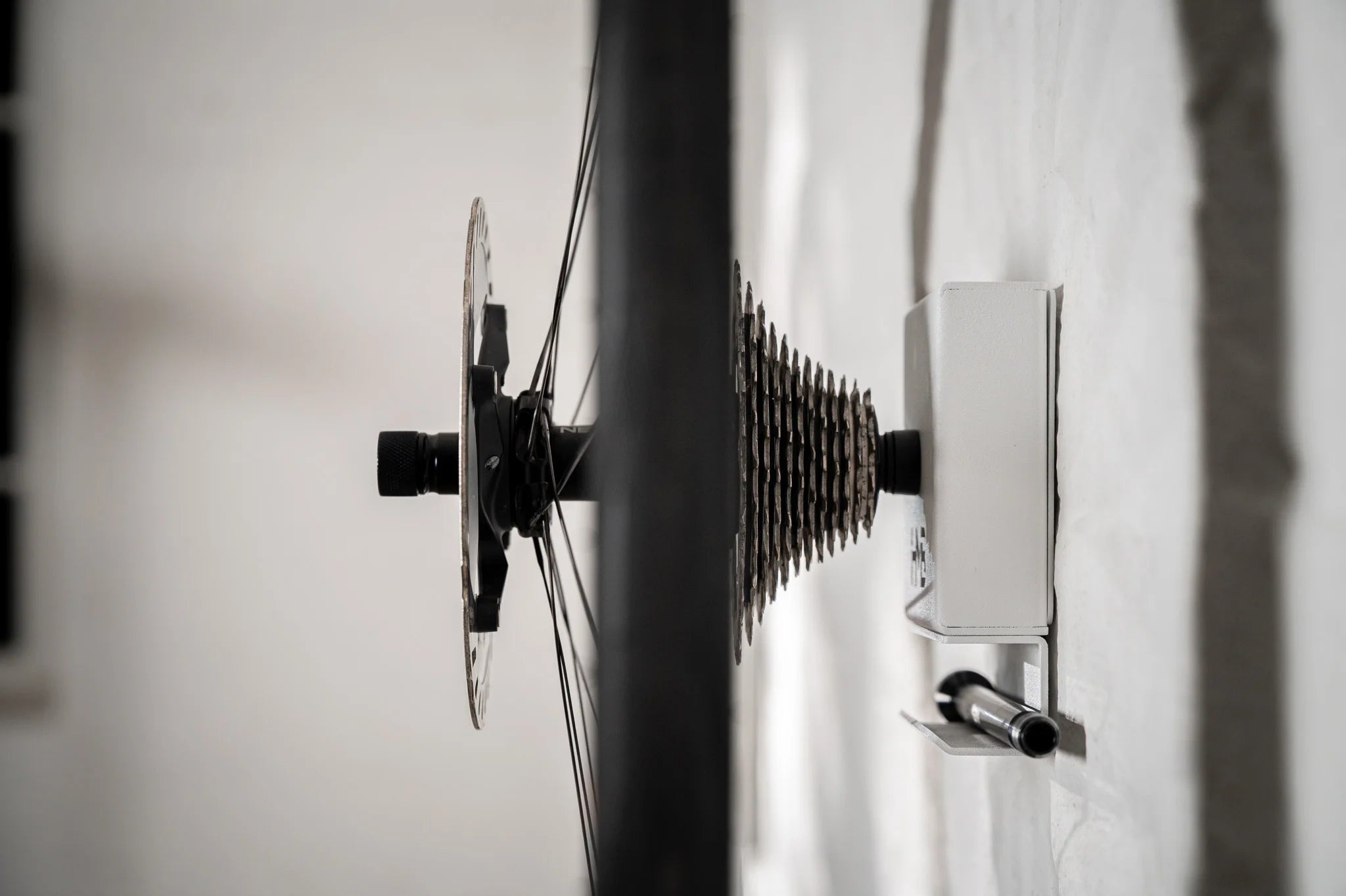 Detailed side view of the Hold My Bike (HMB) wheel mount: A rear wheel with cassette is securely mounted on the axle, with an integrated shelf below to store the bike's thru-axle.