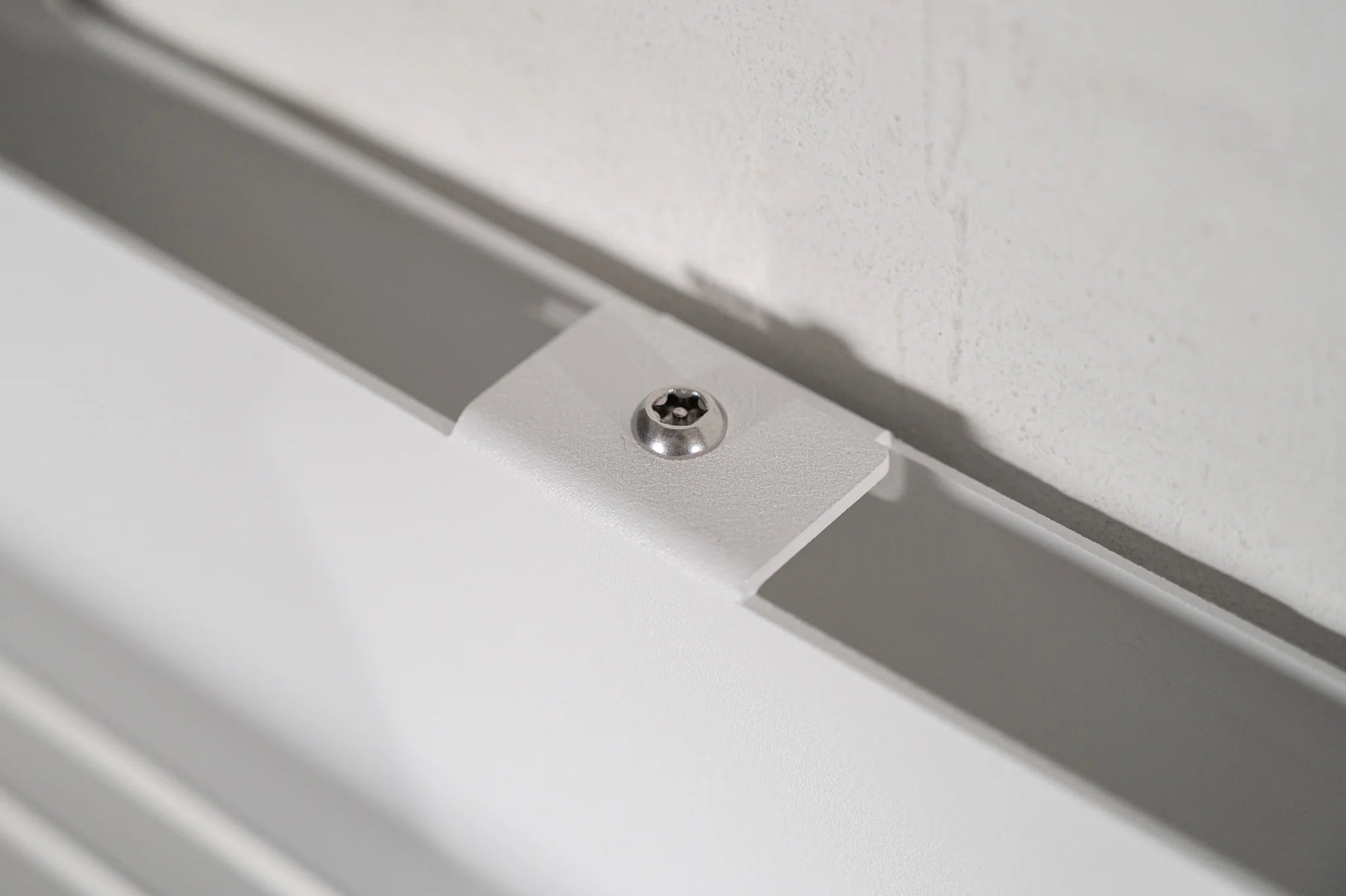 Close-up of the security screw on the Hold My Bike (HMB) wall mount, acting as an anti-theft measure to prevent the mount from being removed from the wall