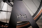 Close-up of the black Hold My Bike (HMB) bike stand made of durable metal, featuring a high-quality powder-coated finish and a precision laser-cut HMB logo.