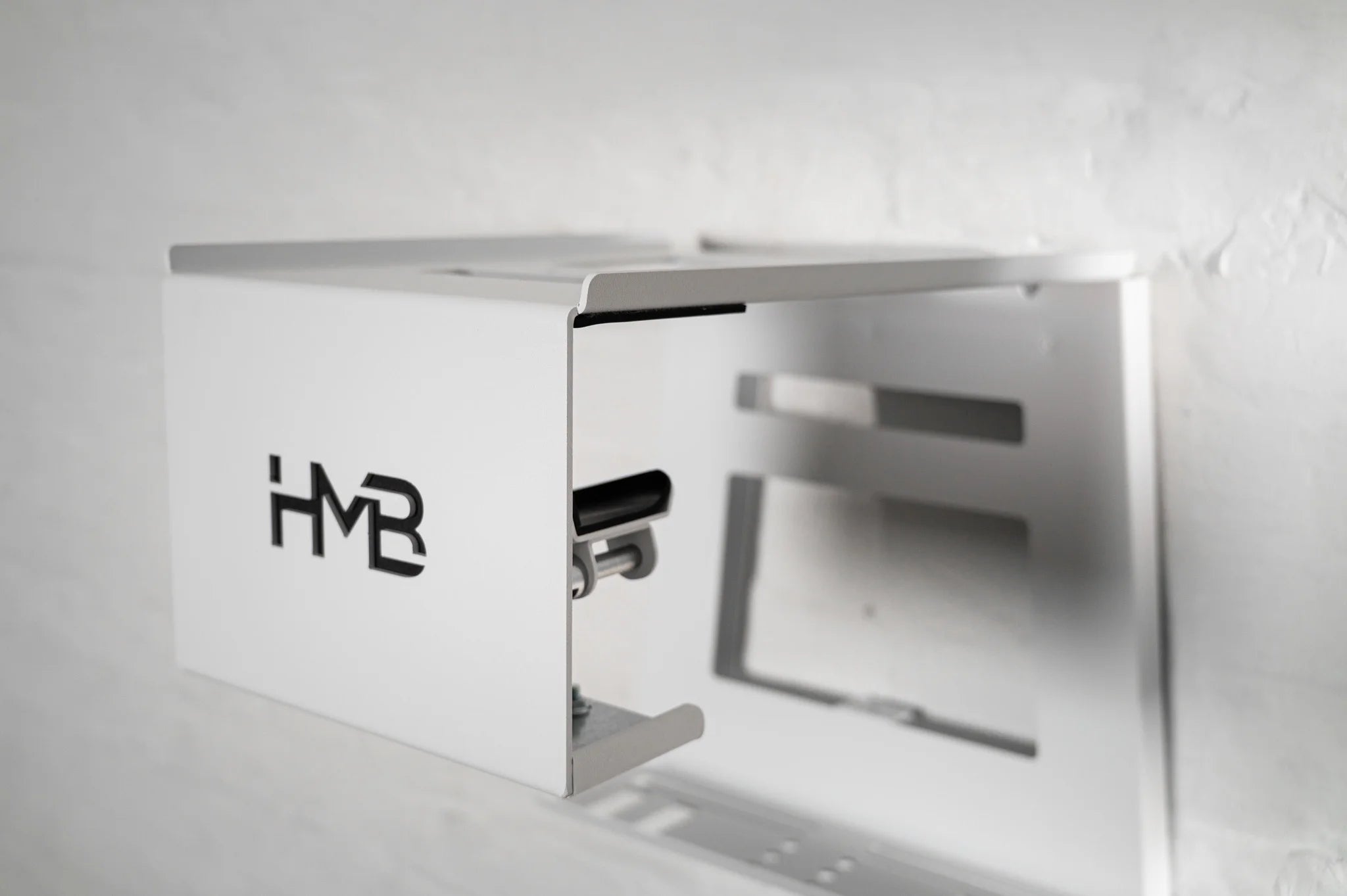 Perspective view of the white HMB Ultimate XL wall mount featuring the innovative HMB tilt mechanism, designed to adjust the bike's storage angle for a perfect fit and optimal space efficiency.